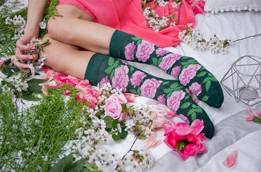 Woman wearing beautiful green cotton socks with pink roses motifs 